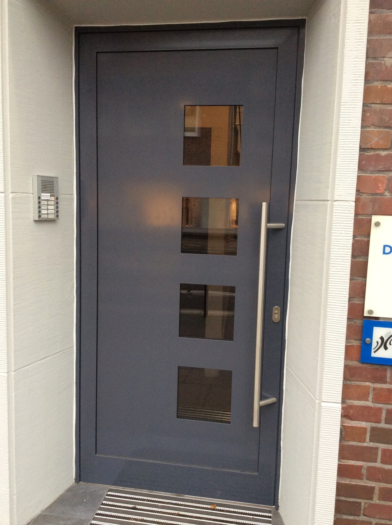 Moderne anthrazitfarbene Aluminium-Haustür mit Glasstreifen